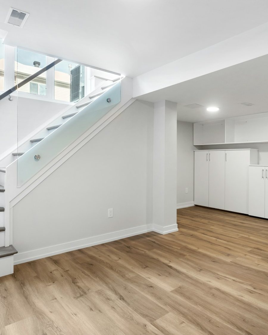 A finished basement with stairs and a desk