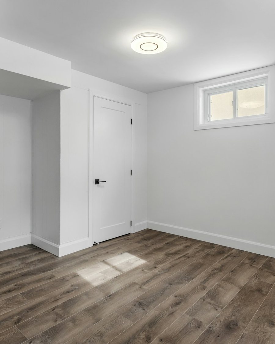A freshly painted room with new plank flooring